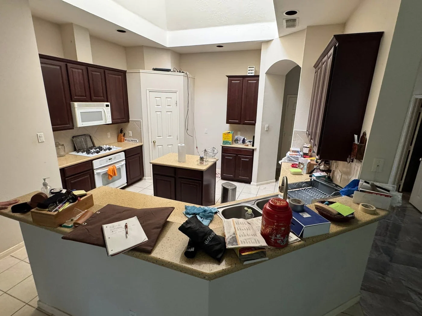 A Houston kitchen with dark cabinets reworked into an open white kitchen before the remodel