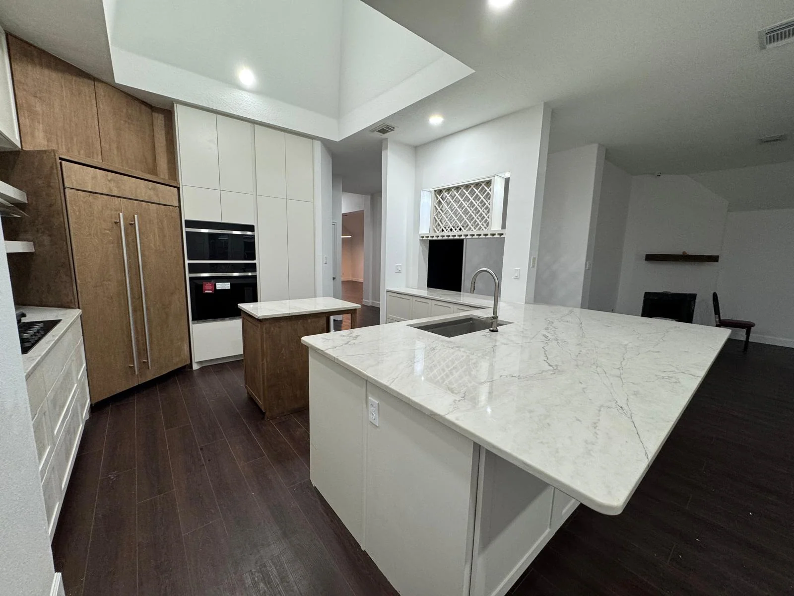 Kitchen by LL General Contractor with a quartz island and built-in wall ovens