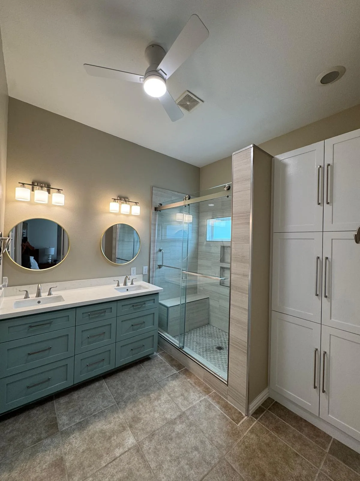 Bathroom vanity with twin sinks and a fitted linen tower built by LL General Contractor