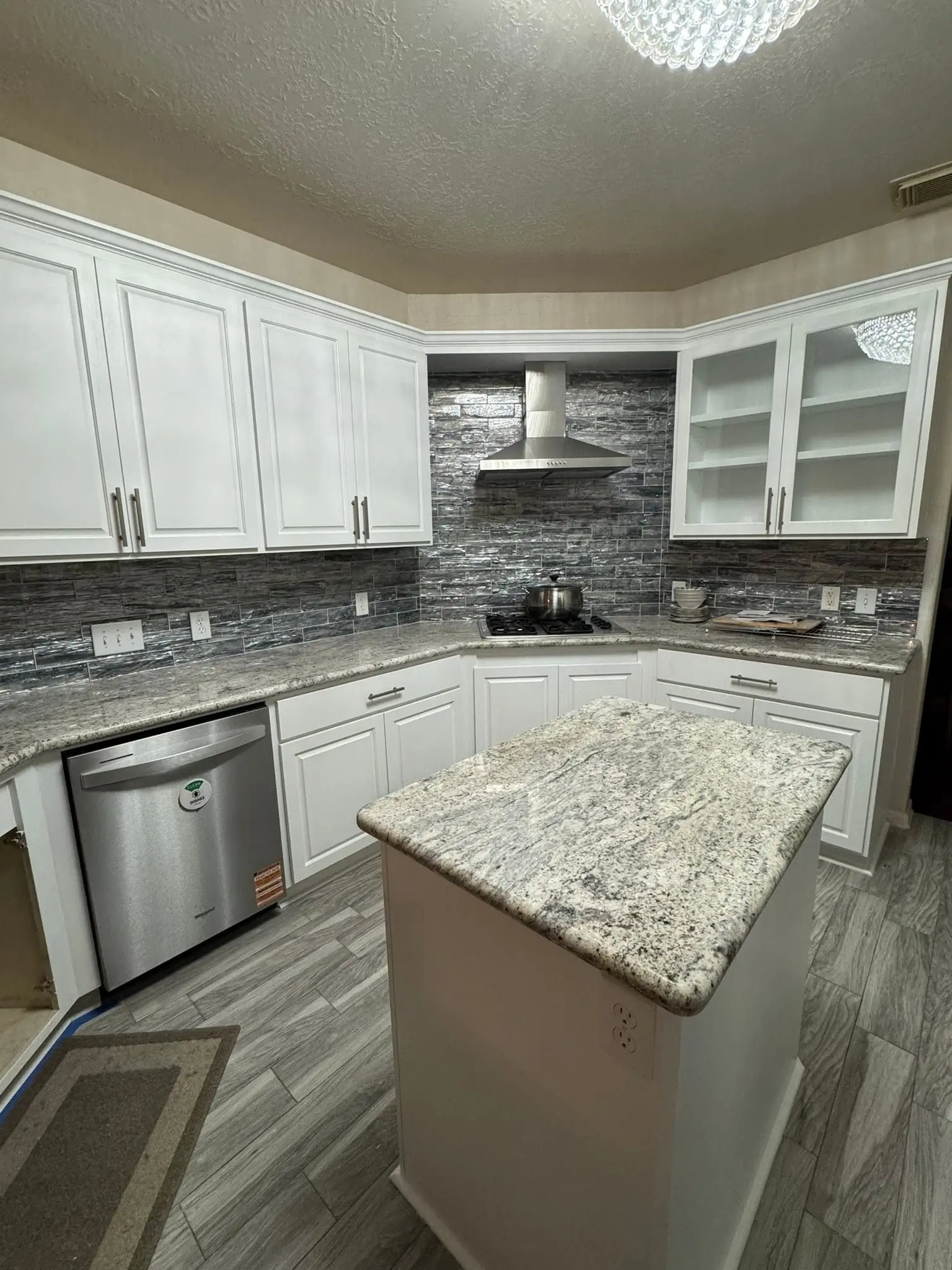 Kitchen cabinets with a painted finish and glass fronted uppers by LL General Contractor